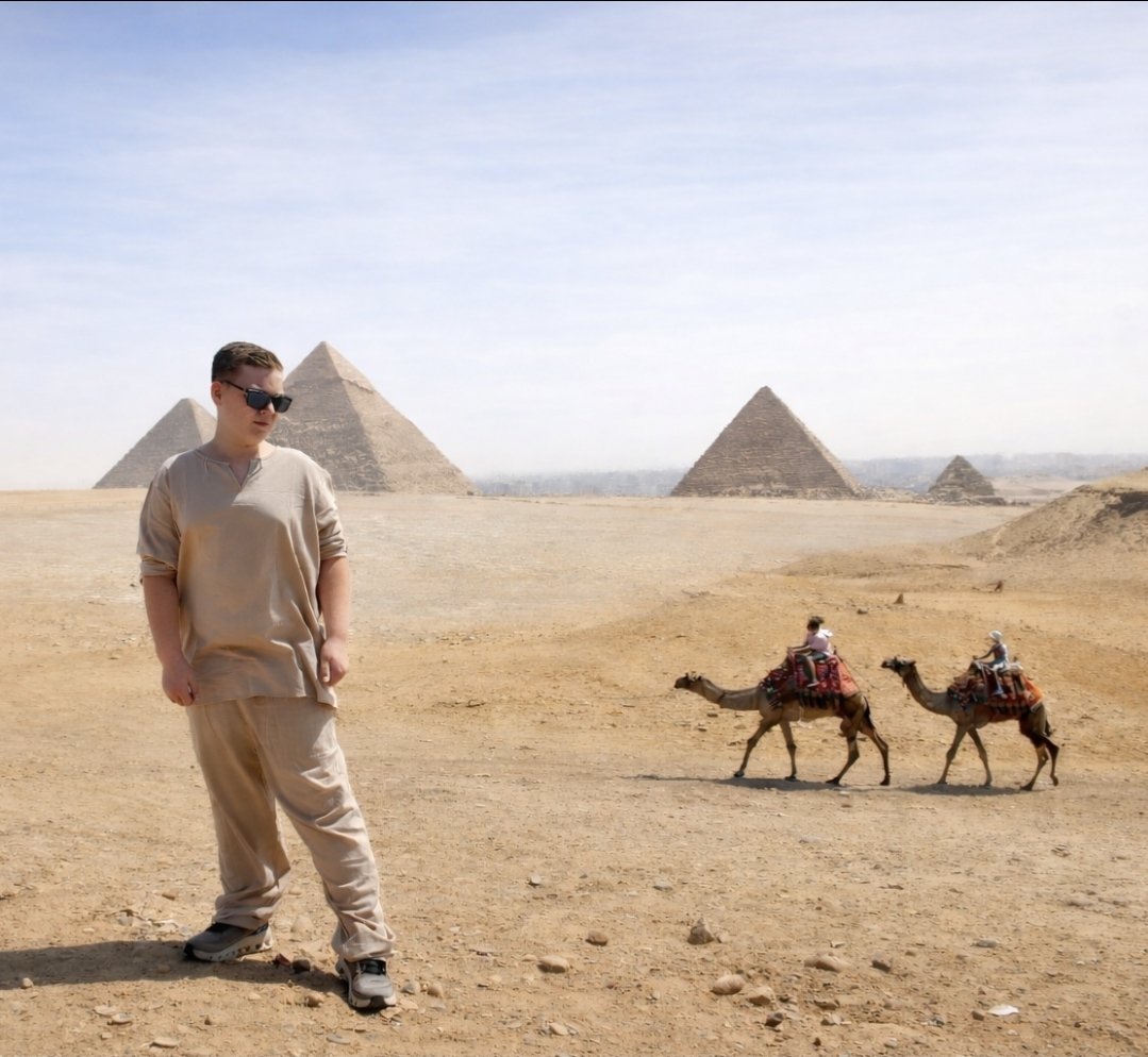 Tayden Franklin standing in the desert in front of the pyramids of Egypt, with camels walking behind him