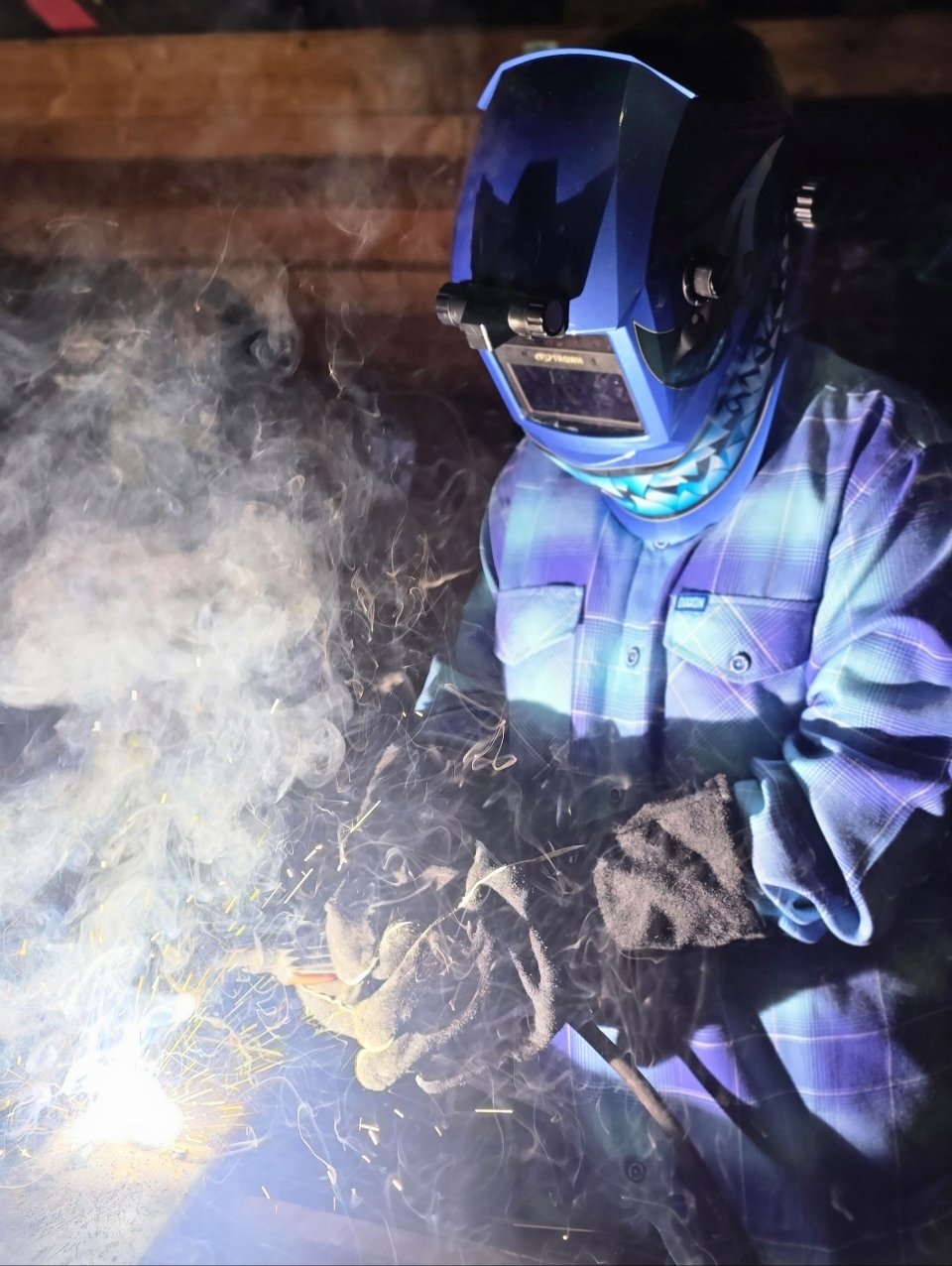Tayden Franklin welding at night, sparks flying
